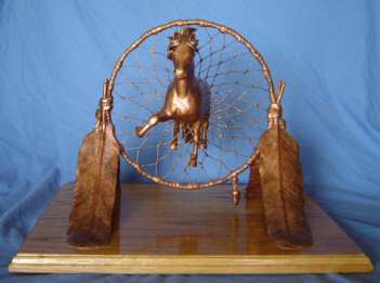 One of a kind clay sculpture of a horse coming through a dream catcher.
